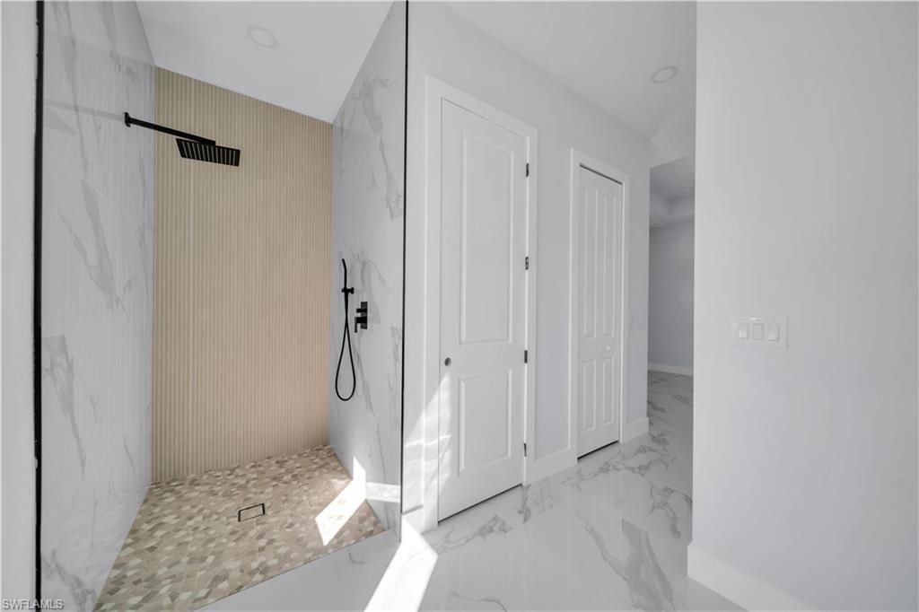 Full bathroom featuring a marble finish shower and light marble finish floors