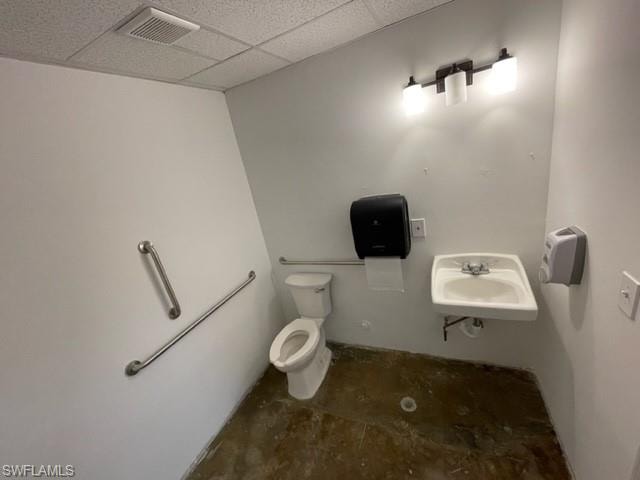 Bathroom with toilet and a paneled ceiling