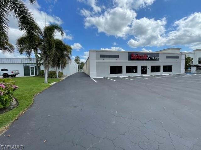 View of commercial property featuring uncovered parking