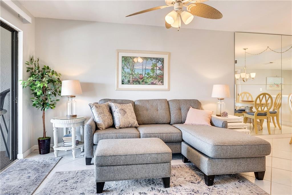 Living area featuring a ceiling fan, a chandelier, and light tile patterned floors