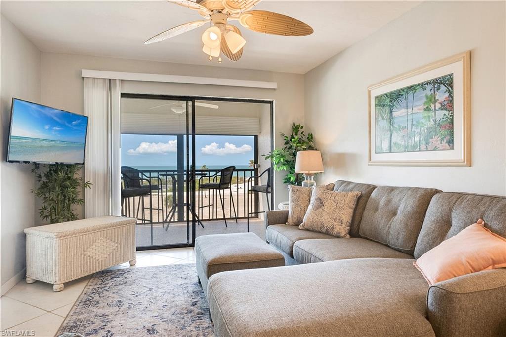Living room with a ceiling fan and tile patterned flooring