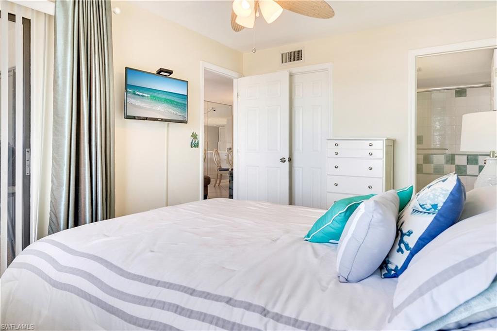 Bedroom featuring ensuite bath and a ceiling fan