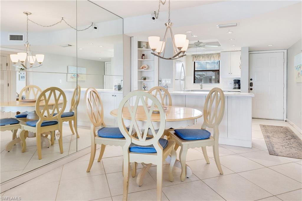 Dining space with a chandelier, light tile patterned floors, and ceiling fan
