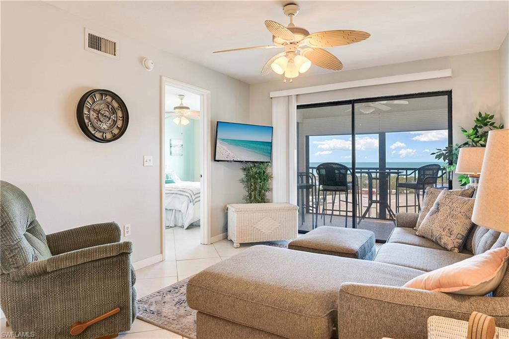 Living room featuring light tile patterned floors and ceiling fan