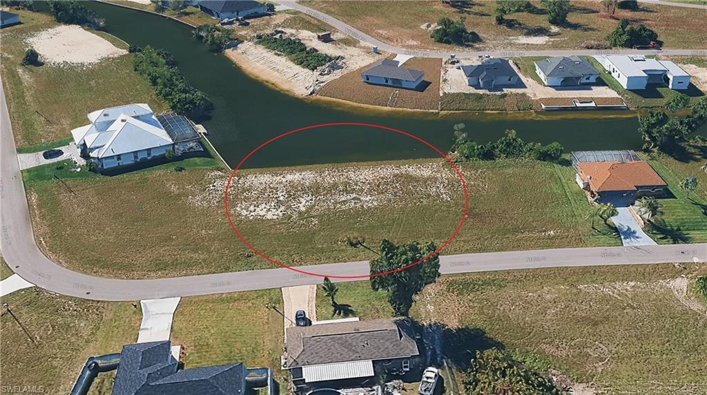 Aerial view of residential area featuring a nearby body of water