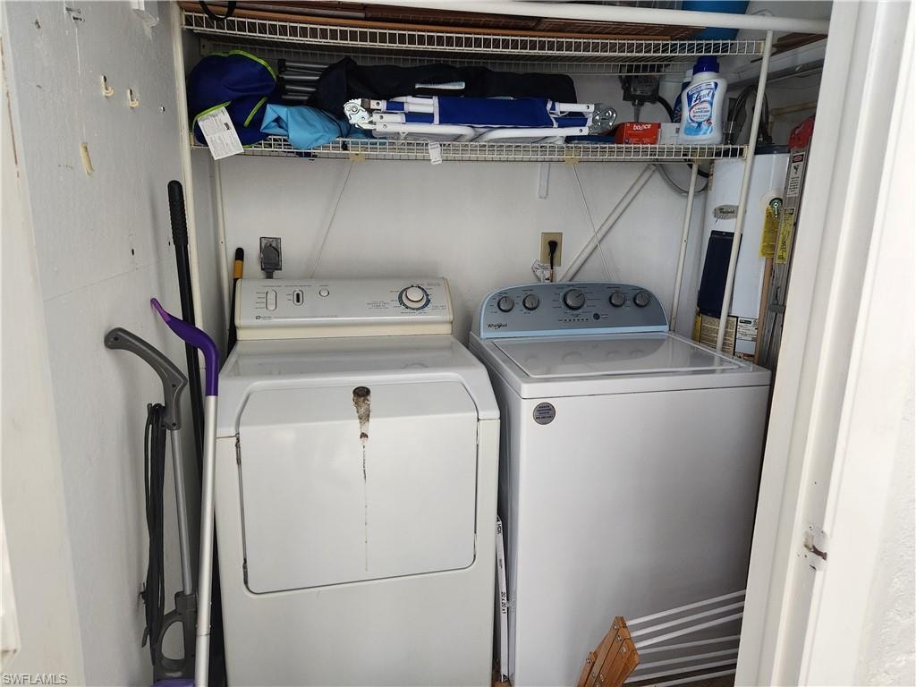 Laundry area with water heater and washing machine and clothes dryer