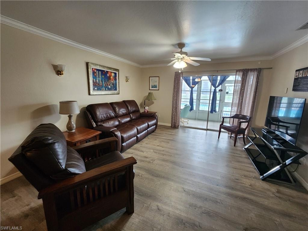 Living area with ornamental molding, wood finished floors, and ceiling fan