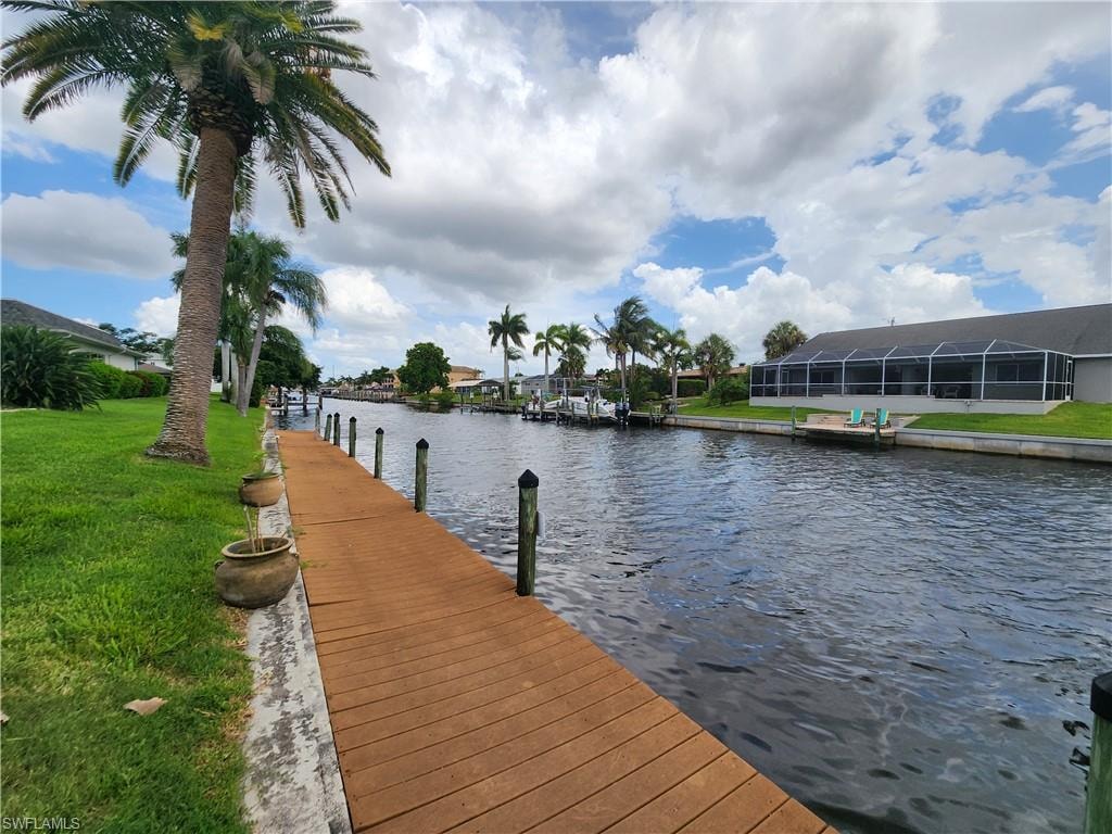 Dock with a water view and a lawn