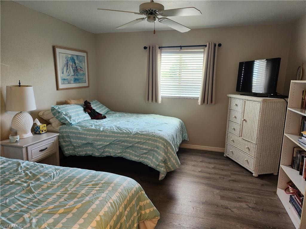 Bedroom with dark wood-type flooring and a ceiling fan