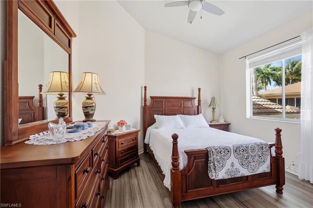 Bedroom featuring vaulted ceiling, dark wood-style flooring, and a ceiling fan