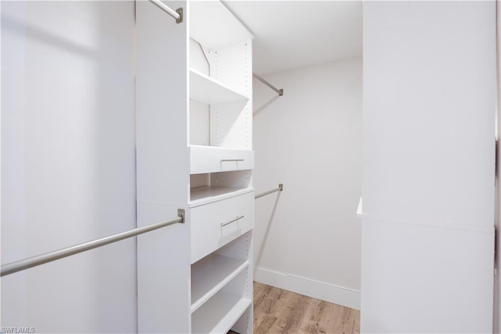 Walk in closet with light wood-style flooring
