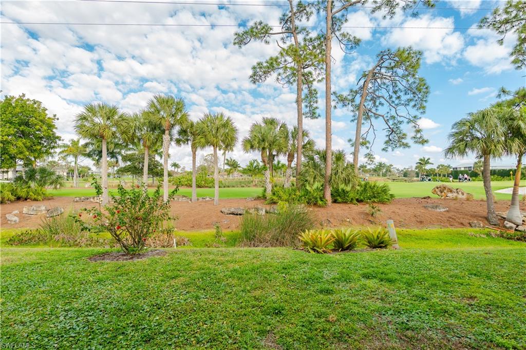 View of green lawn with view of golf course