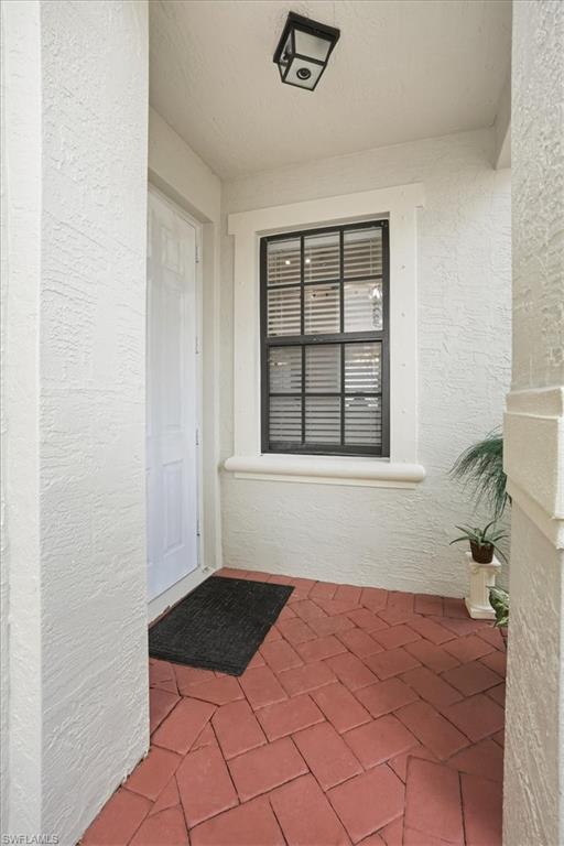 Doorway to property featuring stucco siding