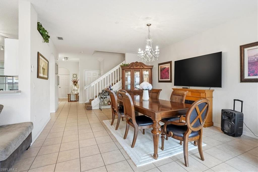 Dining space featuring suspended lighting, light tile patterned floors, and arched walkways