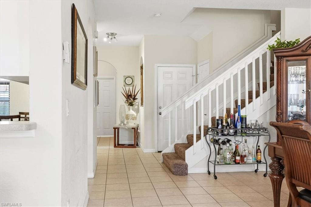 Foyer featuring stairway and light tile patterned floors