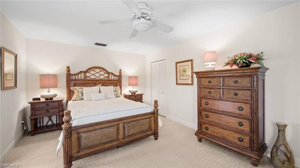 Bedroom featuring a closet, light colored carpet, and a ceiling fan