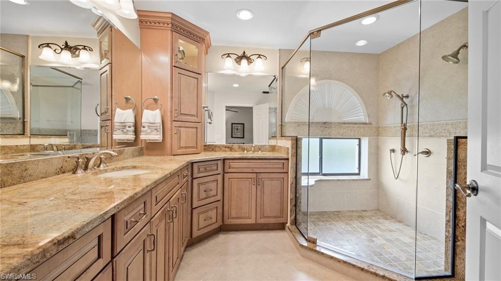 Full bath featuring double vanity, a shower stall, and recessed lighting