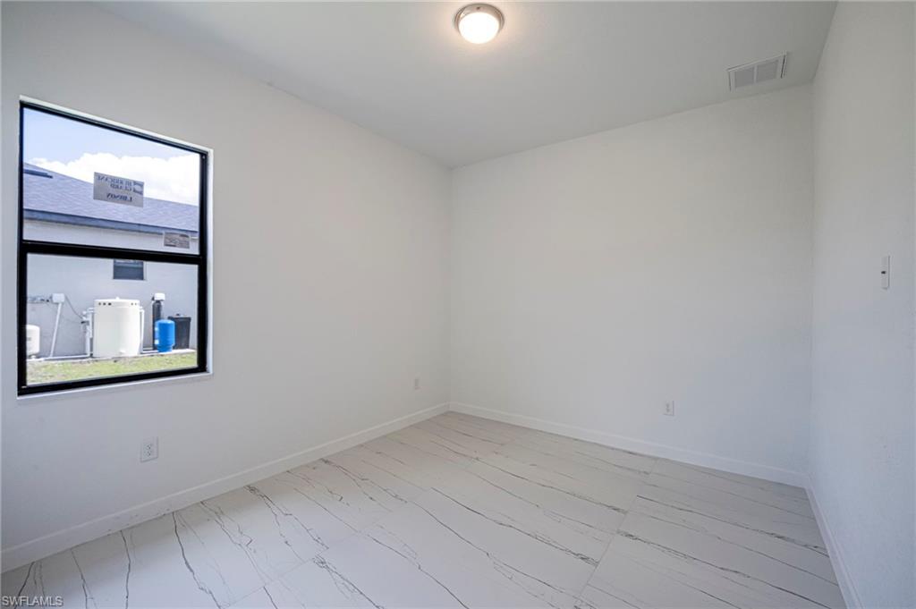 Unfurnished room with baseboards and light marble finish flooring