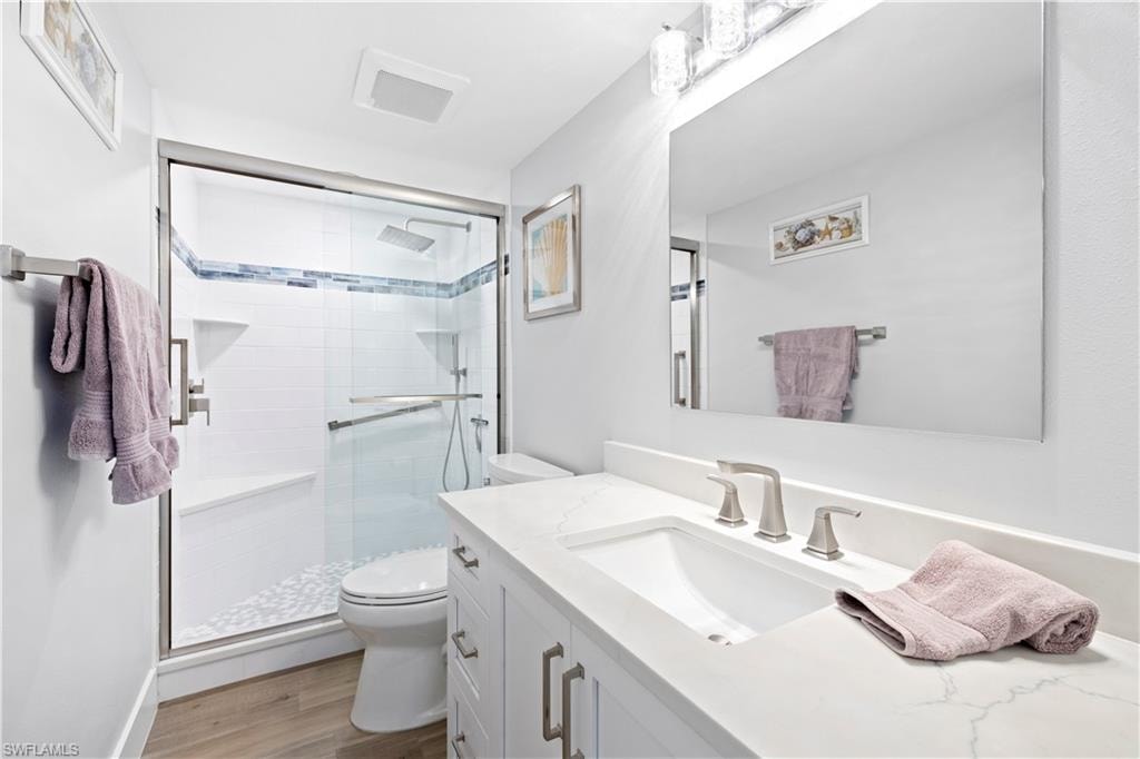 Bathroom featuring vanity, a shower stall, and wood finished floors