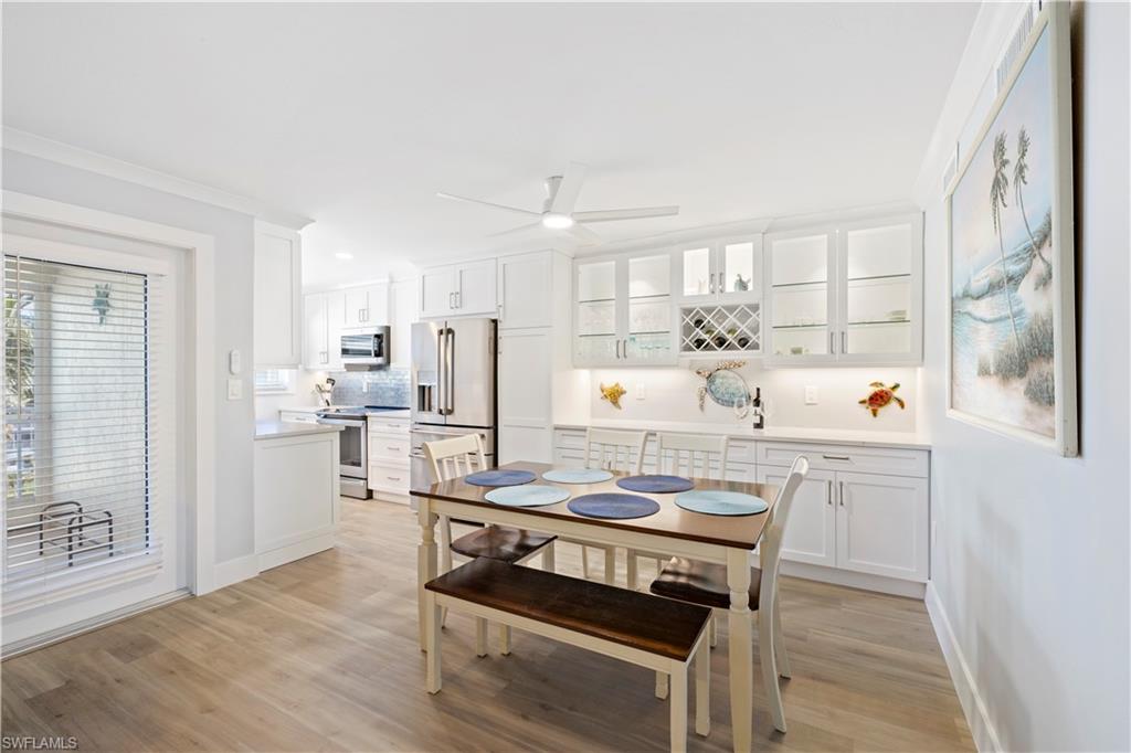 Dining room featuring light wood-style floors, a ceiling fan, and ornamental molding