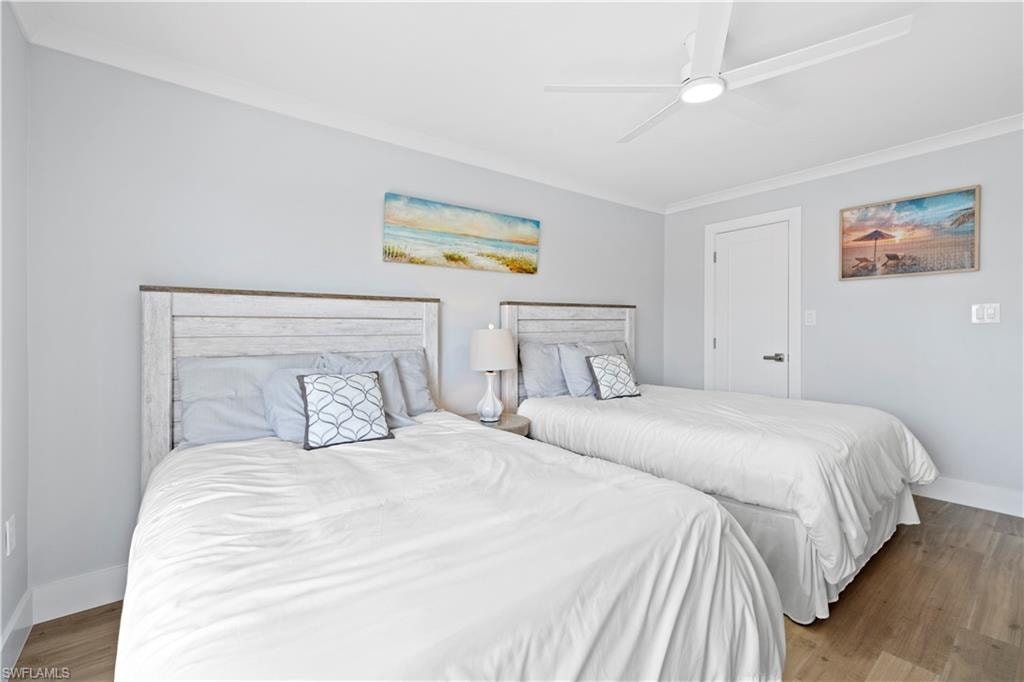 Bedroom featuring crown molding, wood finished floors, and ceiling fan