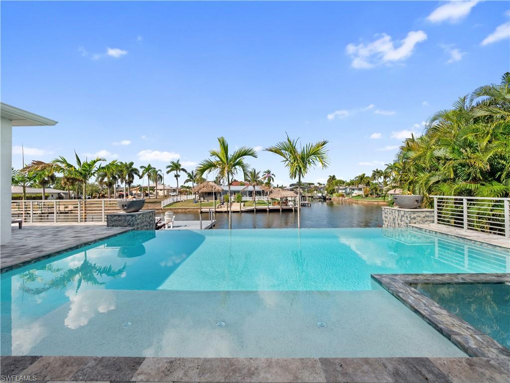 Relaxing pool / spa with a water view and a patio area