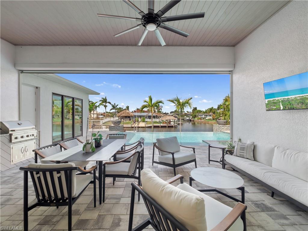 View of patio / terrace featuring ceiling fan, area for grilling, outdoor lounge area, and a water view