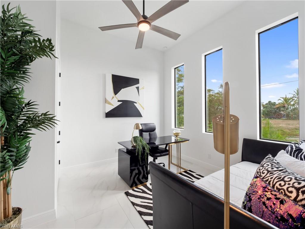 Bedroom with a desk, light marble finish flooring, and ceiling fan