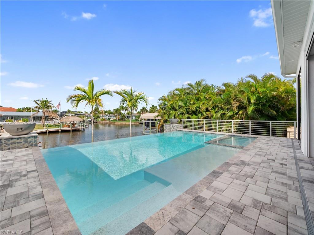 Relaxing pool / spa with a patio and a water view