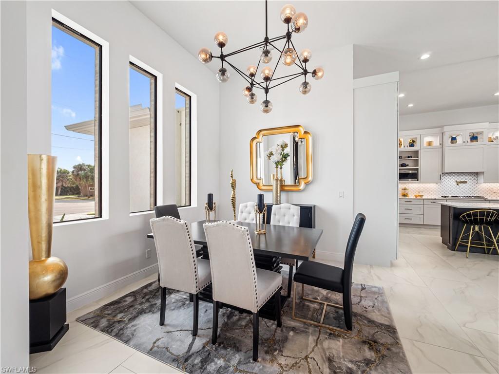 Dining room featuring a chandelier and baseboards