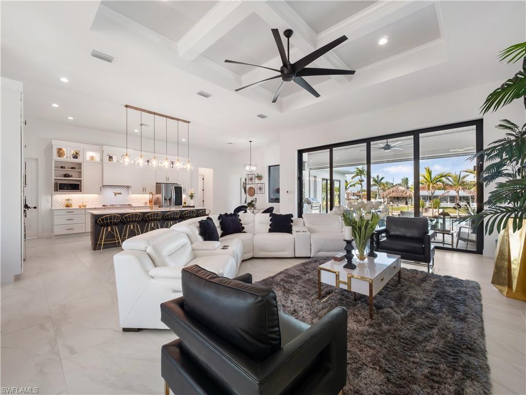 Living area featuring coffered ceiling, a ceiling fan, and hanging lights