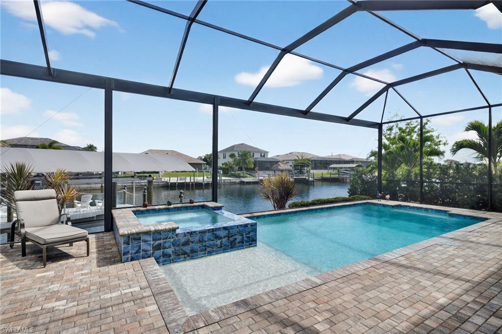 Integrated pool / spa with a lanai and a water view