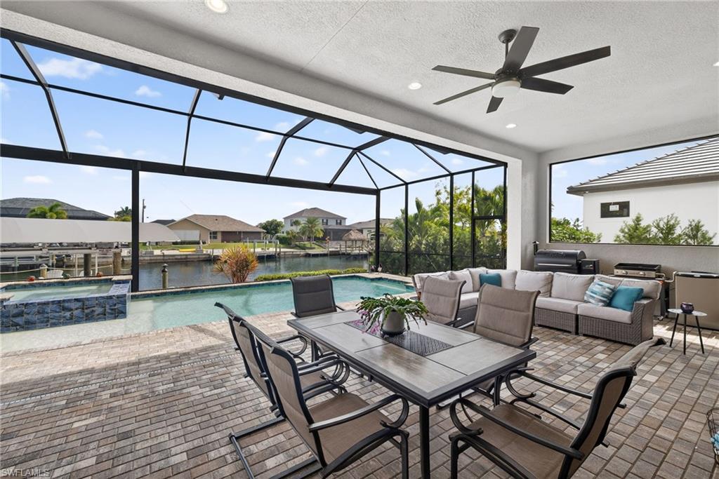 View of lanai, a pool with connected hot tub, large dock, tiki bar and a beautiful water view