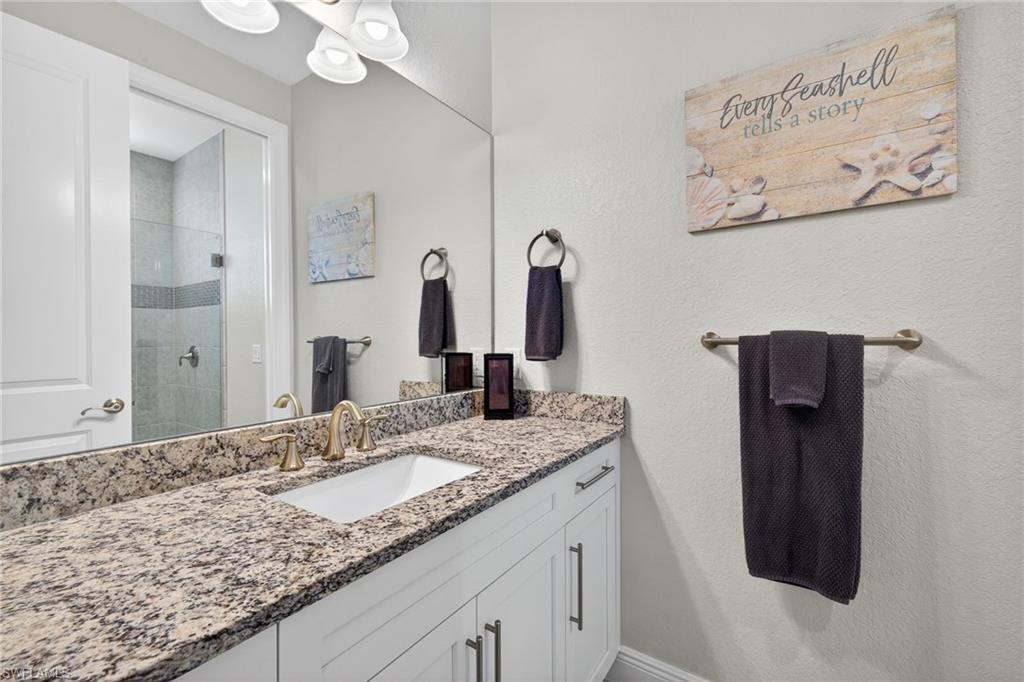 Ensuite bathroom featuring large vanity and a luxury shower stall