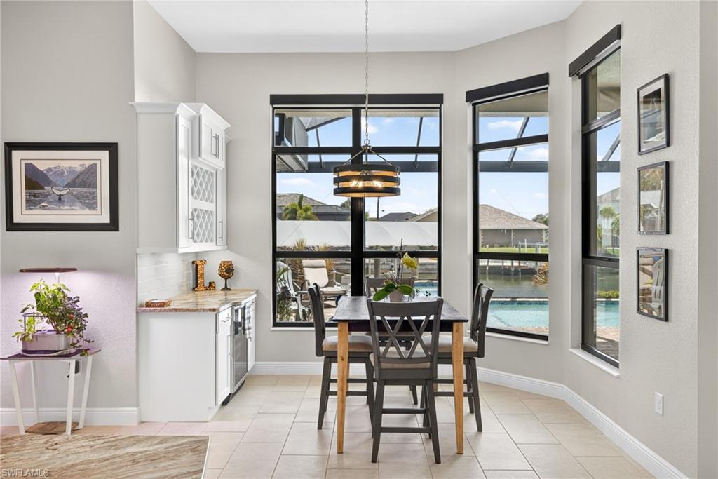 Dining space featuring wine bar and wine cooler, and overlooking the pool and canal