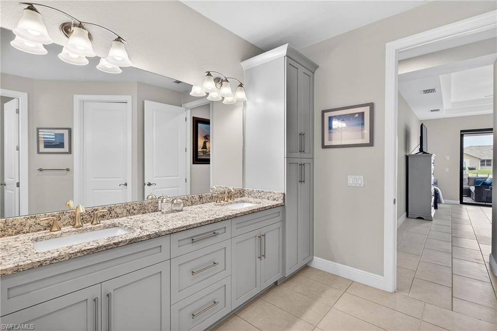 Full bathroom featuring double vanity, a garden tub, a shower stall, and light tile patterned floors