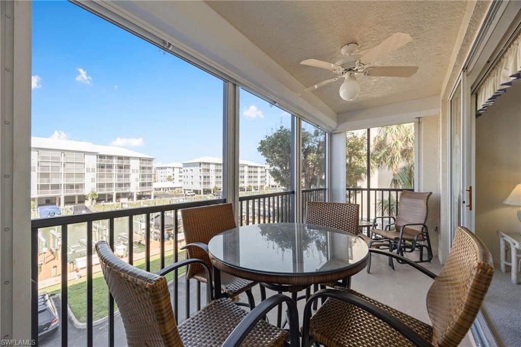 Sunroom / solarium with a balcony, ceiling fan, and outdoor dining space