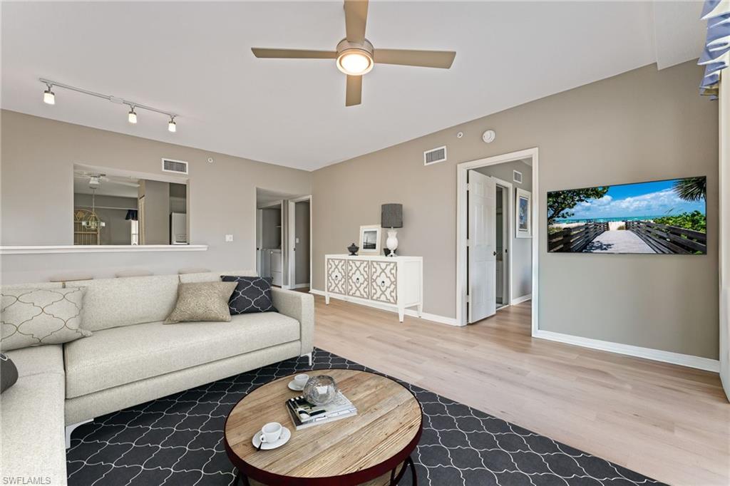 Living area with ceiling fan and light wood-style floors