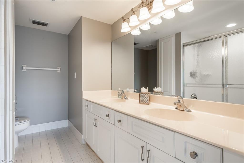 Full bathroom with double vanity, light tile patterned flooring, a stall shower, and a bidet