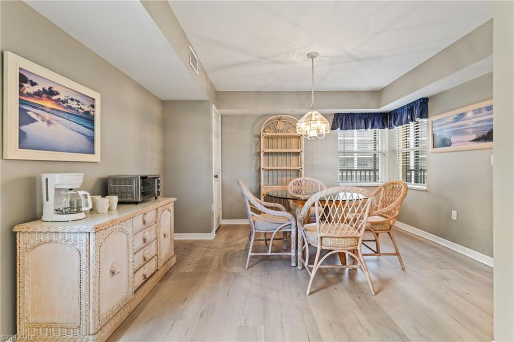 Dining space with light wood-style floors and suspended lighting