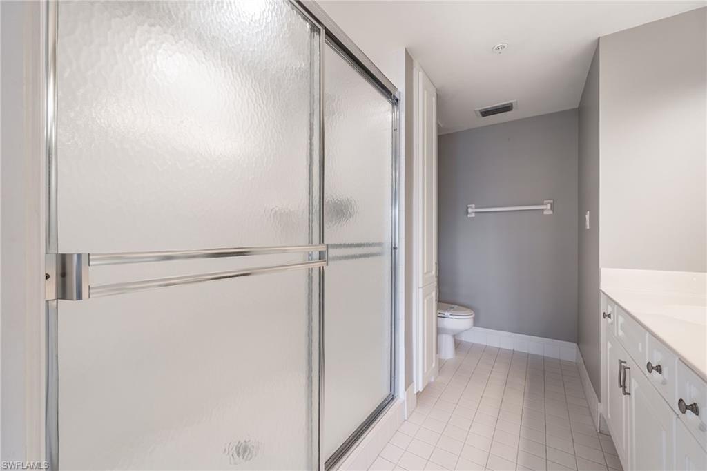 Bathroom with vanity, a shower stall, and light tile patterned flooring