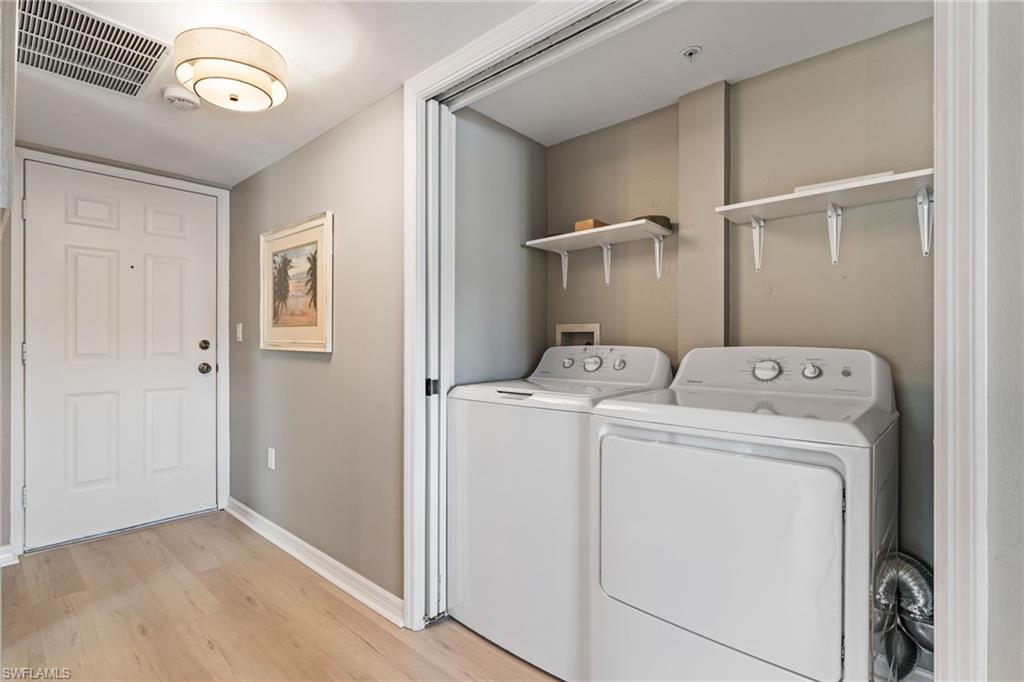 Laundry area featuring light wood-style flooring and washer and clothes dryer