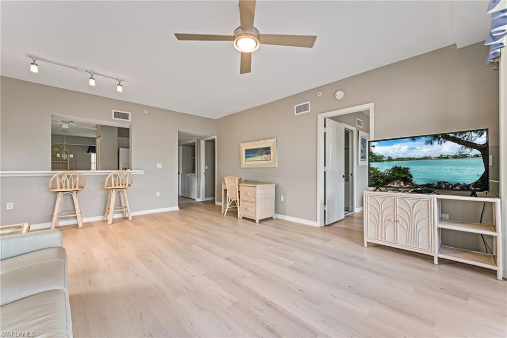Living area with a ceiling fan and light wood finished floors