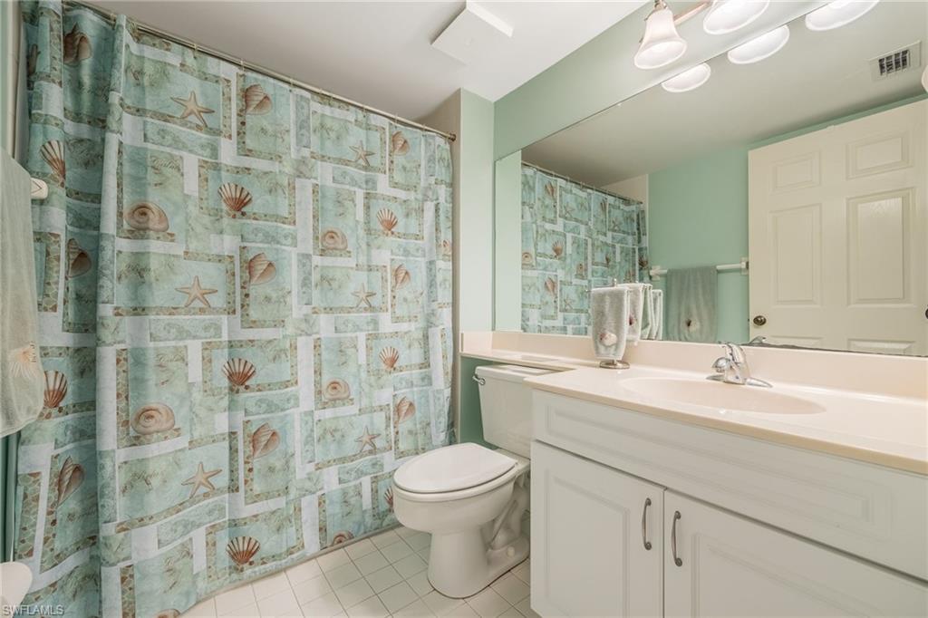 Full bathroom featuring vanity, a shower with shower curtain, and light tile patterned floors