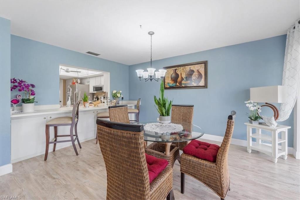 Dining room with light wood-style floors and a chandelier