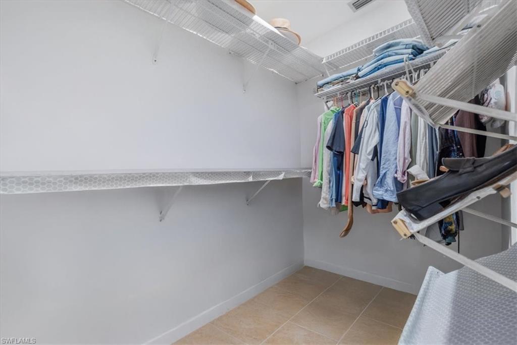 Walk in closet with light tile patterned floors