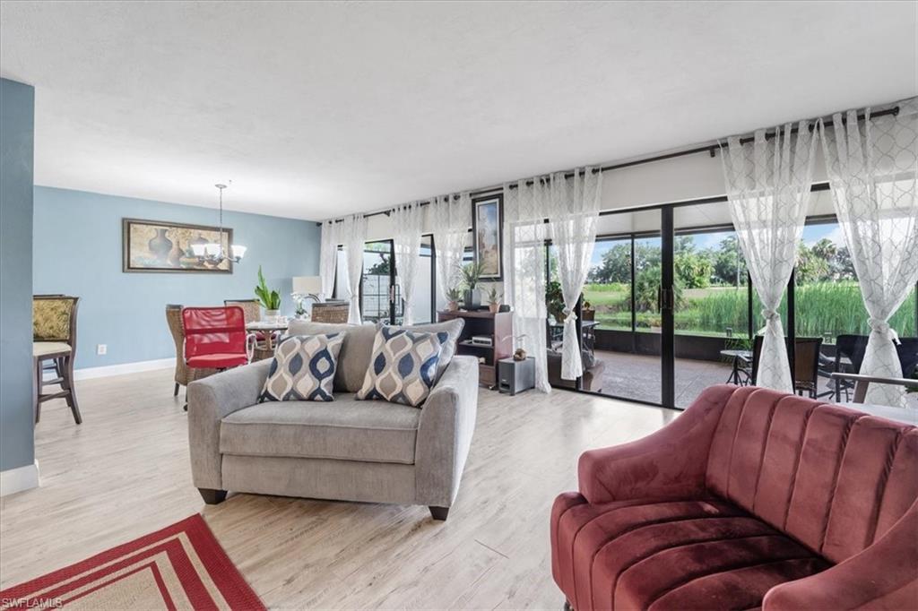 Living area featuring light wood-style flooring and suspended lighting