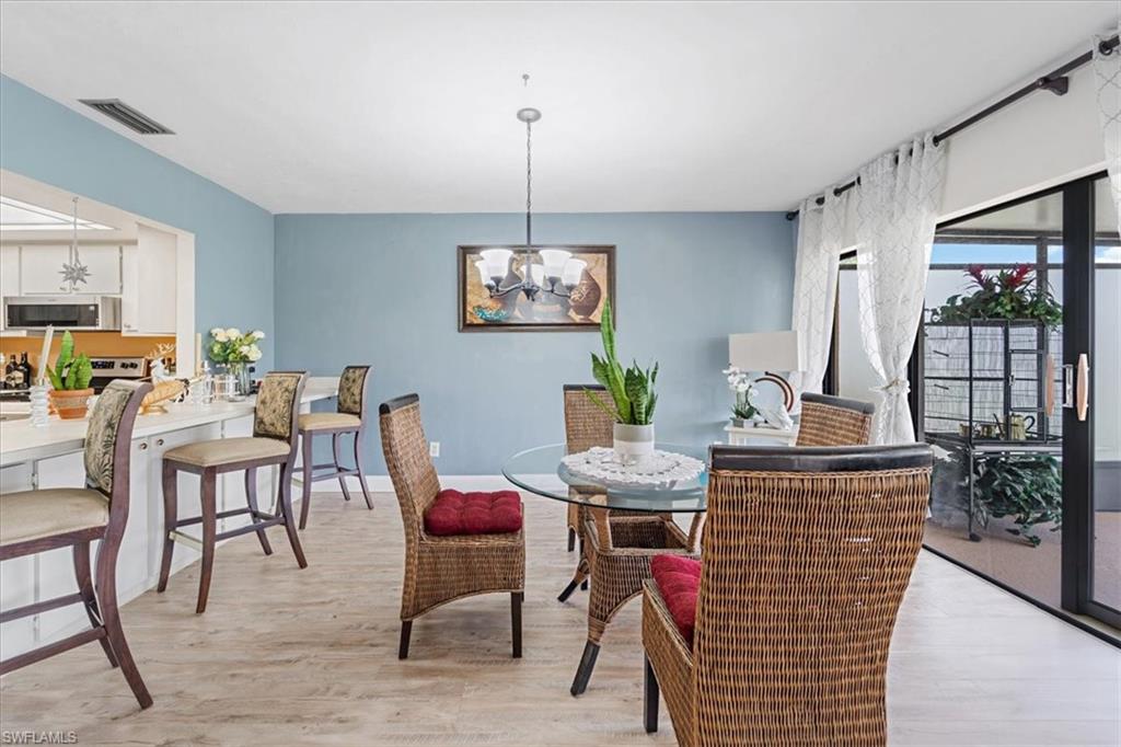 Dining room with suspended lighting and light wood finished floors