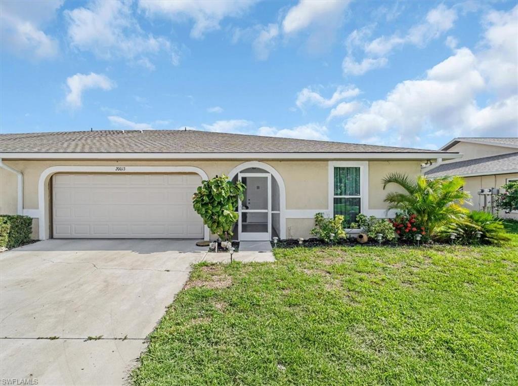 Single story home with stucco siding, driveway, a garage, and a front yard