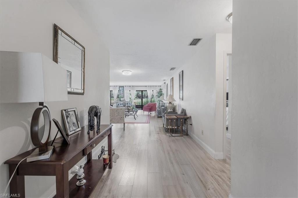Hall with light wood-type flooring and baseboards